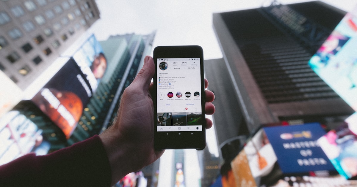 Mano sosteniendo un celular con la aplicación de Instagram abierta mostrando Reels