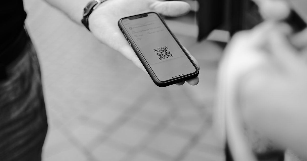 Persona escaneando con su celular un código QR sobre la mesa de un restaurante
